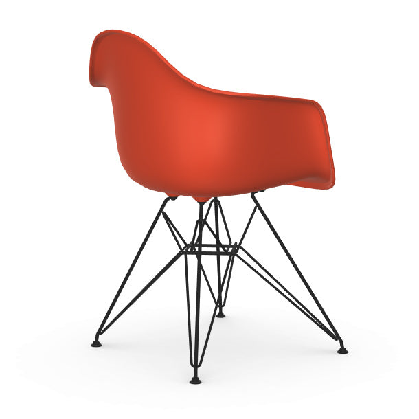 Red Eames chair with black metal legs on a white background